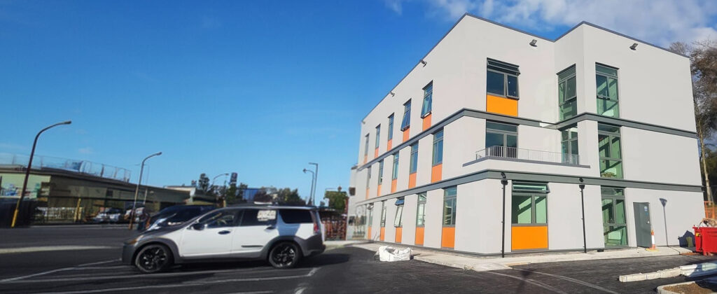 Modern apartment building with white render and coloured panels