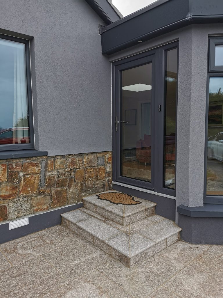 Entrance porch with stone detailing and large glazed panels