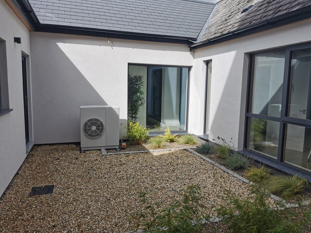 Air source heat pump unit outside a modern home
