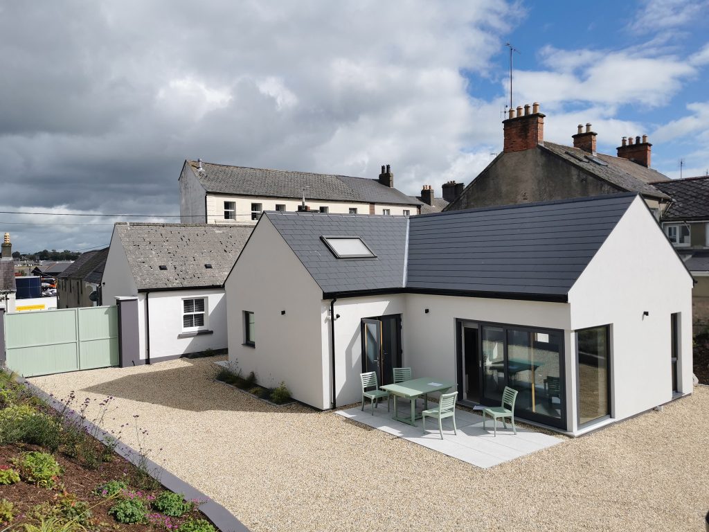Two-storey home with a dark roof and paved patio
