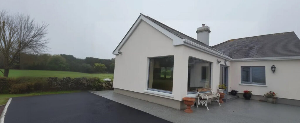 Rendered bungalow with a dark tiled roof in a rural setting
