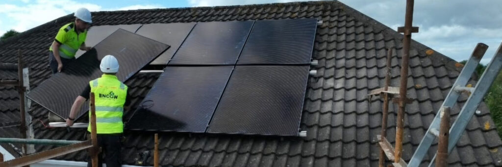 ENCON installer fitting solar panels on a tiled roof